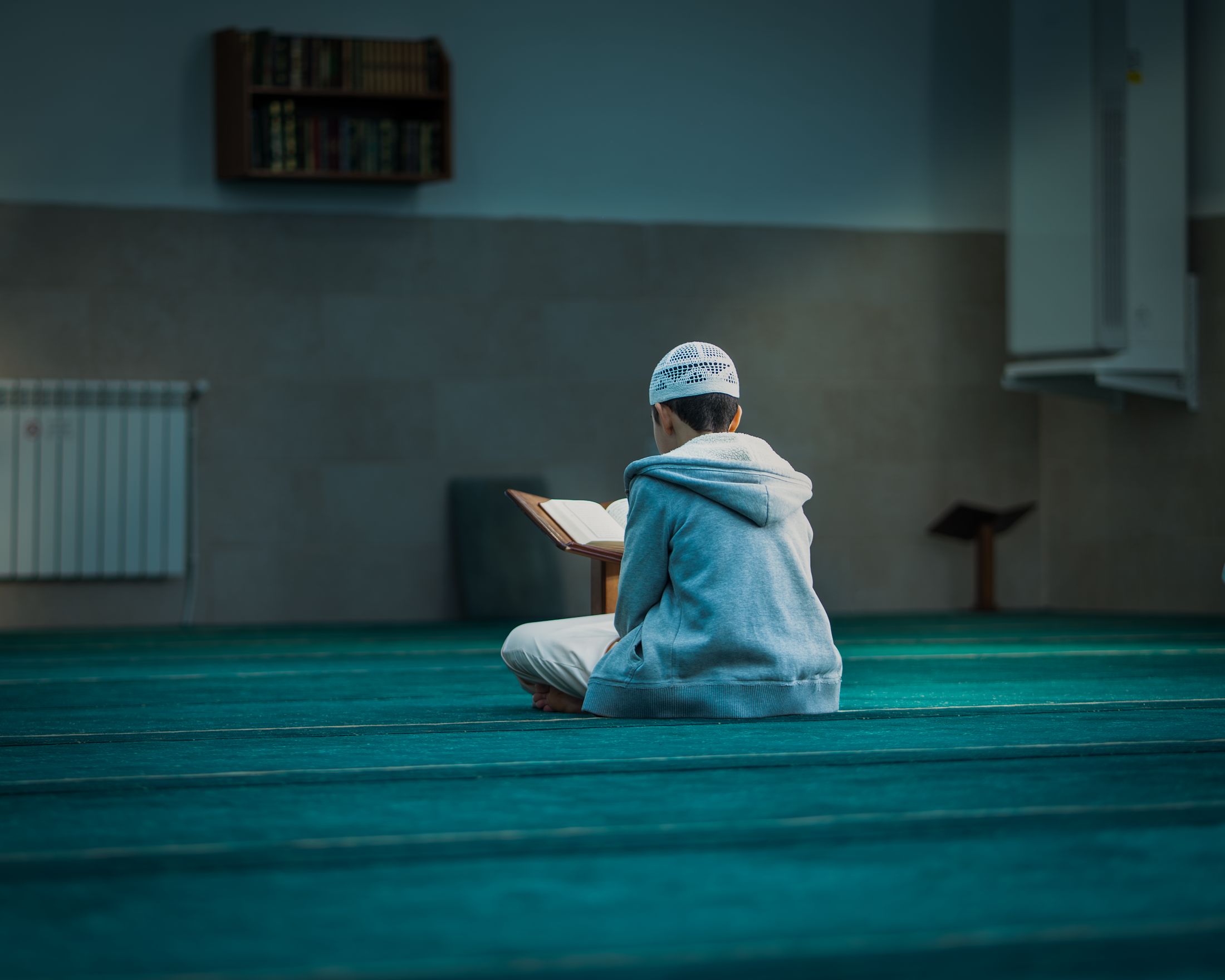 طالب يقرأ القرآن أو يصلي داخل مسجد